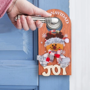 Wooden Christmas door hanger featuring a plush snowman with NAVIDAD and JOY lettering