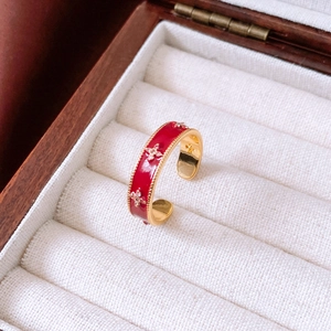 Detail of red enamel flower ring with zircons in a vintage wooden jewelry box