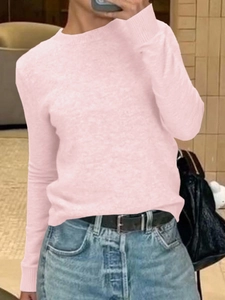 Dettaglio maglione in maglia rosa chiaro a maniche lunghe con jeans blu e cintura