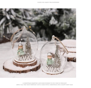 Detail of Christmas glass ball with miniature silver tree and festive wooden base
