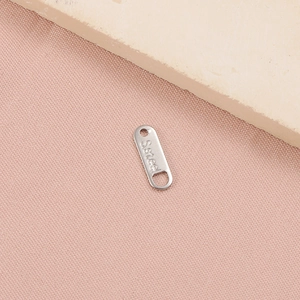 Close-up of oval stainless steel connector charm with S.steel engraving for jewelry DIY