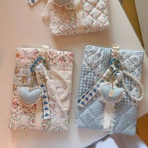 Detail view of quilted floral bags featuring lace ribbons and pearl chain charms