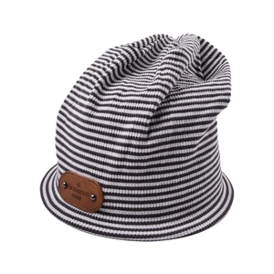 Detail of striped knit beanie showing rib texture and brown leather brand patch with rivets