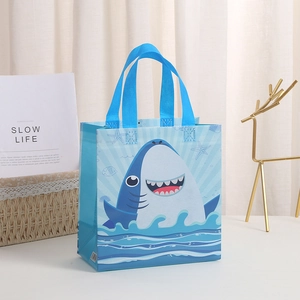 Détail du sac cadeau en non-tissé avec motif de requin et poignées bleues robustes