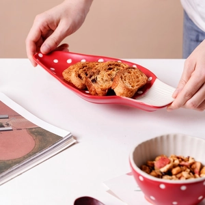 Macro view of red mushroom ceramic plate with white polka dots and stripe pattern