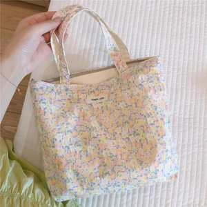 Gros plan du sac en coton fleuri montrant l'étiquette blanche et la texture douce