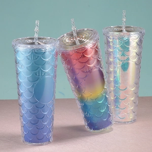 Three gradient mermaid scale tumblers with straws shown on a minimalist counter