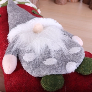 Christmas stocking featuring a grey polka dot gnome with a long white beard on wood floor