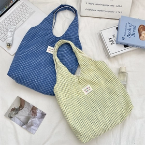 Detailed top view of blue and beige checkered canvas tote bags with woven labels