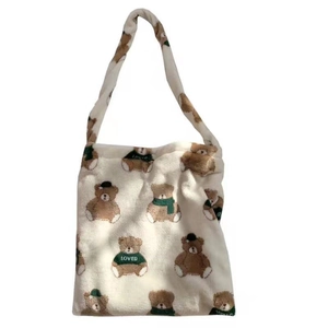 Detail of soft plush tote bag featuring cute cartoon bear prints and fuzzy texture