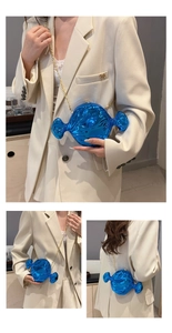 Detail of candy-shaped blue acrylic bag with glossy finish and gold metal chain