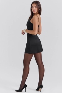 Détail d'une mini robe noire moulante avec de fines bretelles et un design de nœud papillon