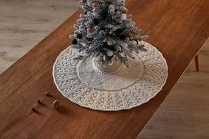Detail of cream-colored knit Christmas tree skirt with textured 3D floral weave pattern