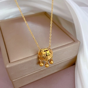 Close-up of golden Fu character longevity lock necklace with three small bell charms