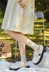Detailed view of floral mesh crew socks with pink tulips and platform Mary Jane shoes
