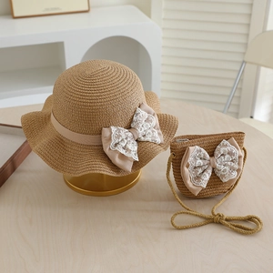 Detailaufnahme von Strohhut und Tasche mit zarten Spitzenbögen für kleine Mädchen