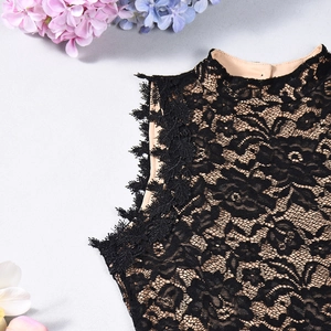 Detail of black lace bodysuit with beige lining and intricate floral embroidery