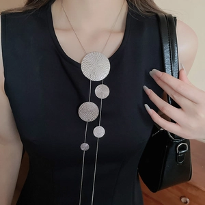 Silver long necklace featuring five textured geometric circular discs on a model