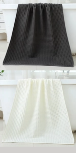 Detail of waffle weave texture on pure cotton towels in dark grey and beige