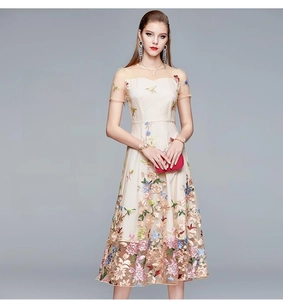 Detail of champagne tulle dress with colorful floral embroidery and cinched waistline