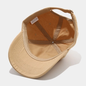 Detail view of khaki cotton baseball cap interior with 100% cotton label and metal buckle