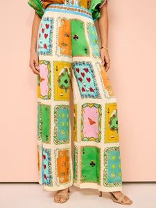 Detail of high-waisted wide-leg trousers with poker card print in satin-finish fabric
