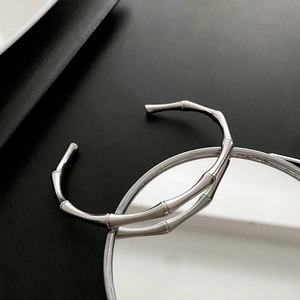 Detailed close-up of a silver bamboo joint open bangle with mirror reflections