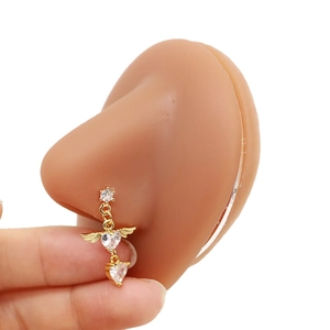 Golden heart nose stud with angel wings and zircon stones on a silicone model