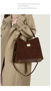 Detail of suede and leather shoulder bag with gold metal buckle and adjustable strap