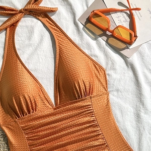 Detailaufnahme der Fischgräten-Textur eines Neckholder-Badeanzugs in gebranntem Orange