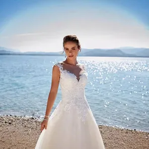 Elegant white lace wedding dress with V-neck embroidery and layered tulle skirt on a model