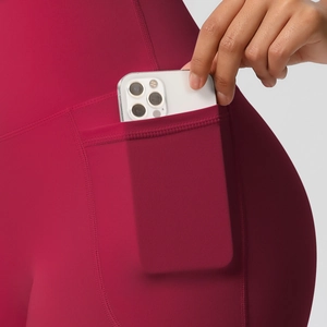 Detail shot of the deep red high-waisted yoga shorts featuring a functional side phone pocket