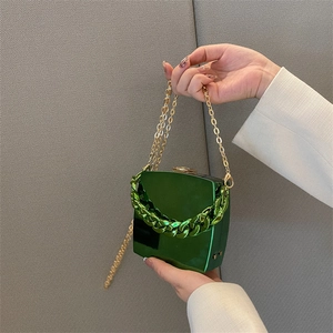 Glossy green box clutch with chunky decorative handle and elegant gold chain strap