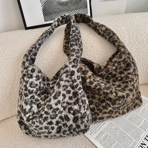 Detailed comparison of gray and brown leopard print faux fur tote bags on a cozy sofa