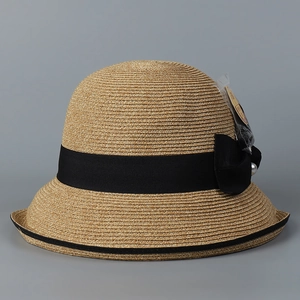 Close-up of fine woven straw texture with elegant black ribbon and pearl detail