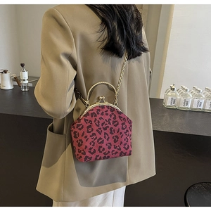 Detail of retro leopard print shell bag with golden metal handle and chain strap on model