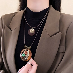 Détail du collier vintage en cuir superposé avec breloques en bronze et bois