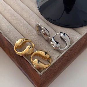 Elegant gold and silver metal teardrop earrings in a velvet lined wooden jewelry box