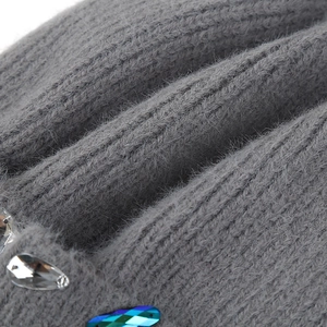 Close-up of grey knit beanie featuring sparkling rhinestones and gradient sequins