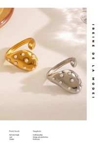 Detailed close-up of liquid metal textured open rings with elegant white pearl inlays