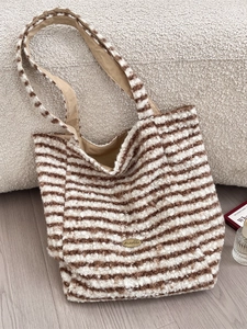 Striped plush tote bag with brown and white faux fur patterns and a metal logo