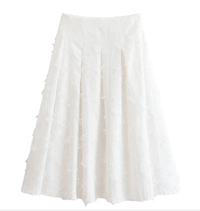 Détail du tissu blanc texturé à franges de plumes de cette élégante jupe midi trapèze