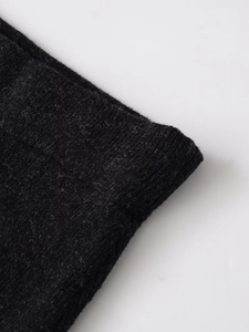 Detailed macro view of black wool knit fabric texture with fine fibrous surface finish