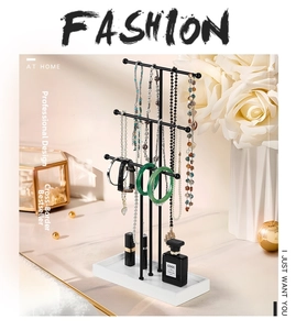 Detailed view of black 3-tier metal jewelry organizer with rectangular marble base