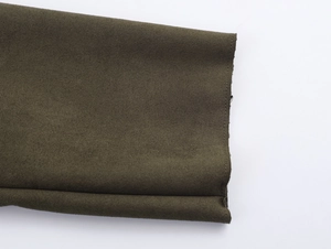 Gros plan détaillé du revers de trench en daim olive avec coutures de précision