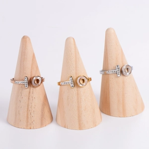 Two-tone T-shaped open ring with pavé diamonds and shell inlay on wooden stands