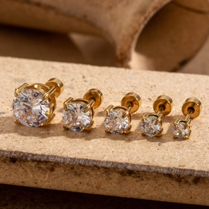 Cinq boucles d'oreilles en acier doré de tailles variées avec zircons étincelants
