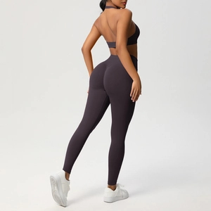 Dettaglio del set yoga viola prugna con reggiseno allacciato al collo e leggings a vita alta