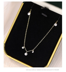 Close-up of gold chain necklace with five sparkling zircons in a black velvet jewelry box