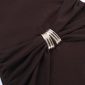 Détail de ferrures métalliques multi-anneaux sur robe marron foncé froncée